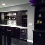 Modern monotone finished basement with custom cabinets Modern monotone finished basement with custom cabinets