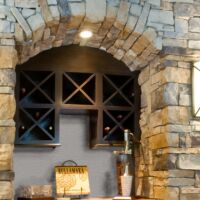Wine nook with custom finishing, sconces and stone
